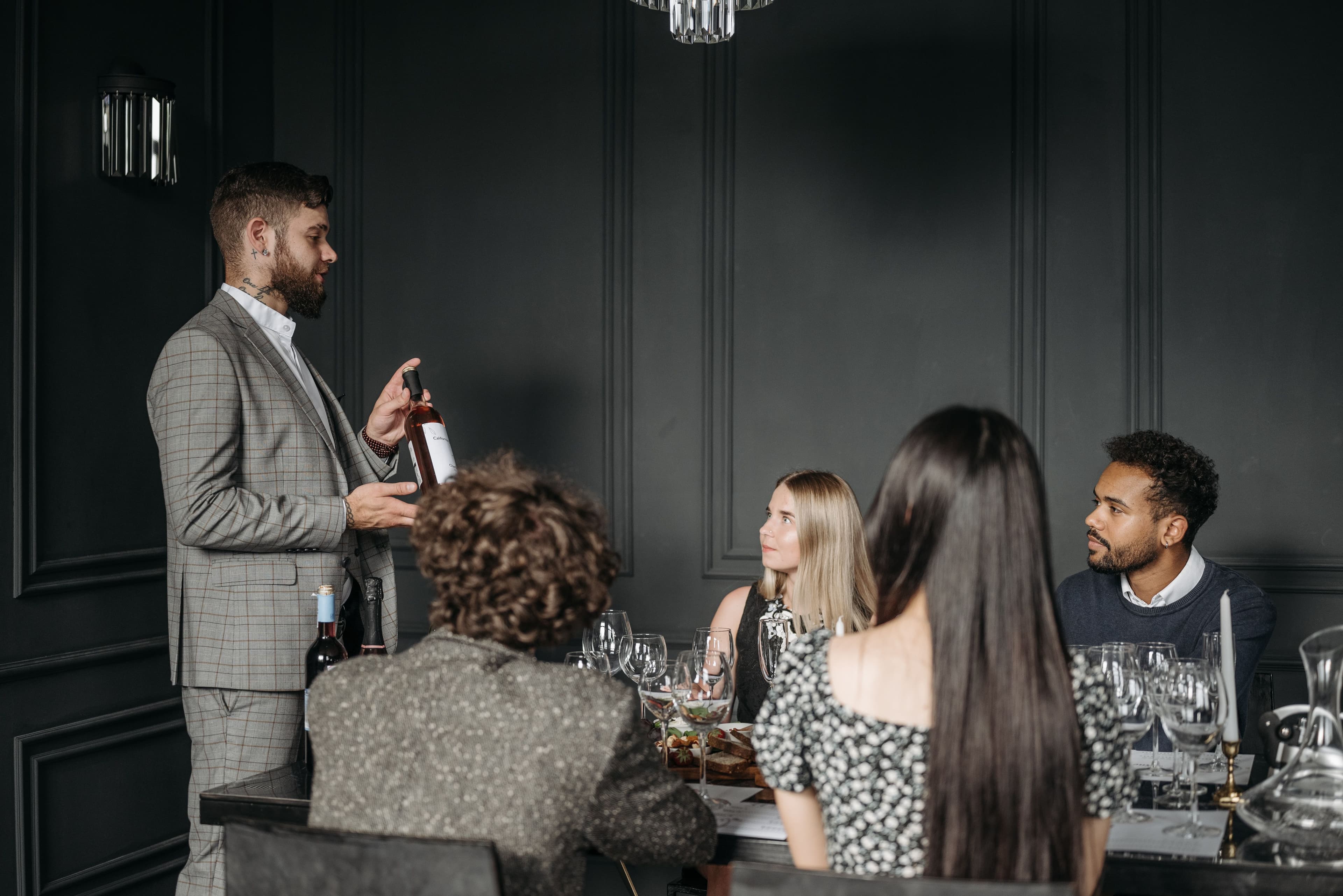 Sommelier presenting wines to trade buyers at an indoor wine tasting event